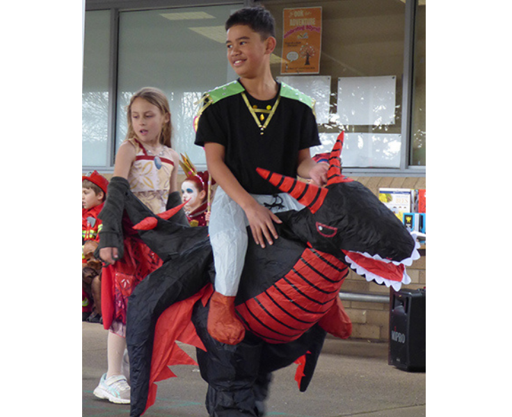 Primary student dressed in dragon costume